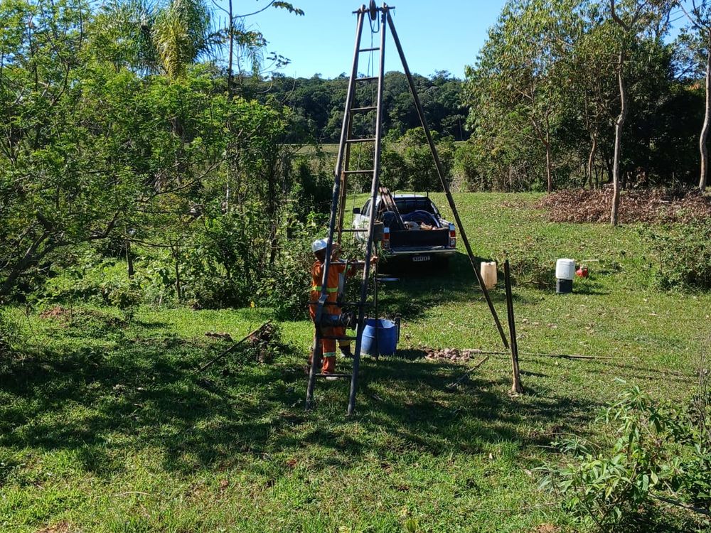 Tripé de sondagem SPT em terreno inclinado com vegetação