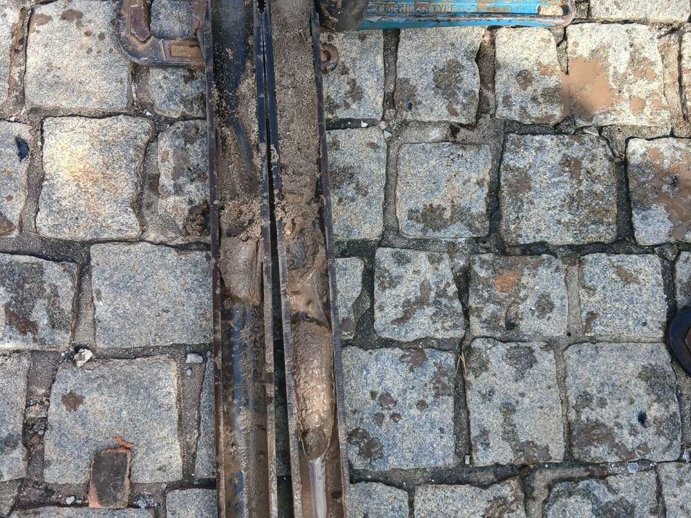 Haste de sondagem SPT atravessando calçamento em lote urbano